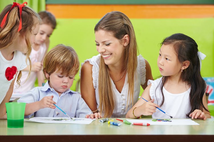 Early childhood educator guiding children with art activities — highlighting childcare educator roles and responsibilities in Australia.