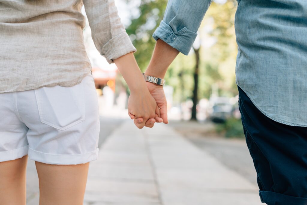 Couple holding hands while walking outdoors — concept image for partner visa Australia or 190 visa with spouse.